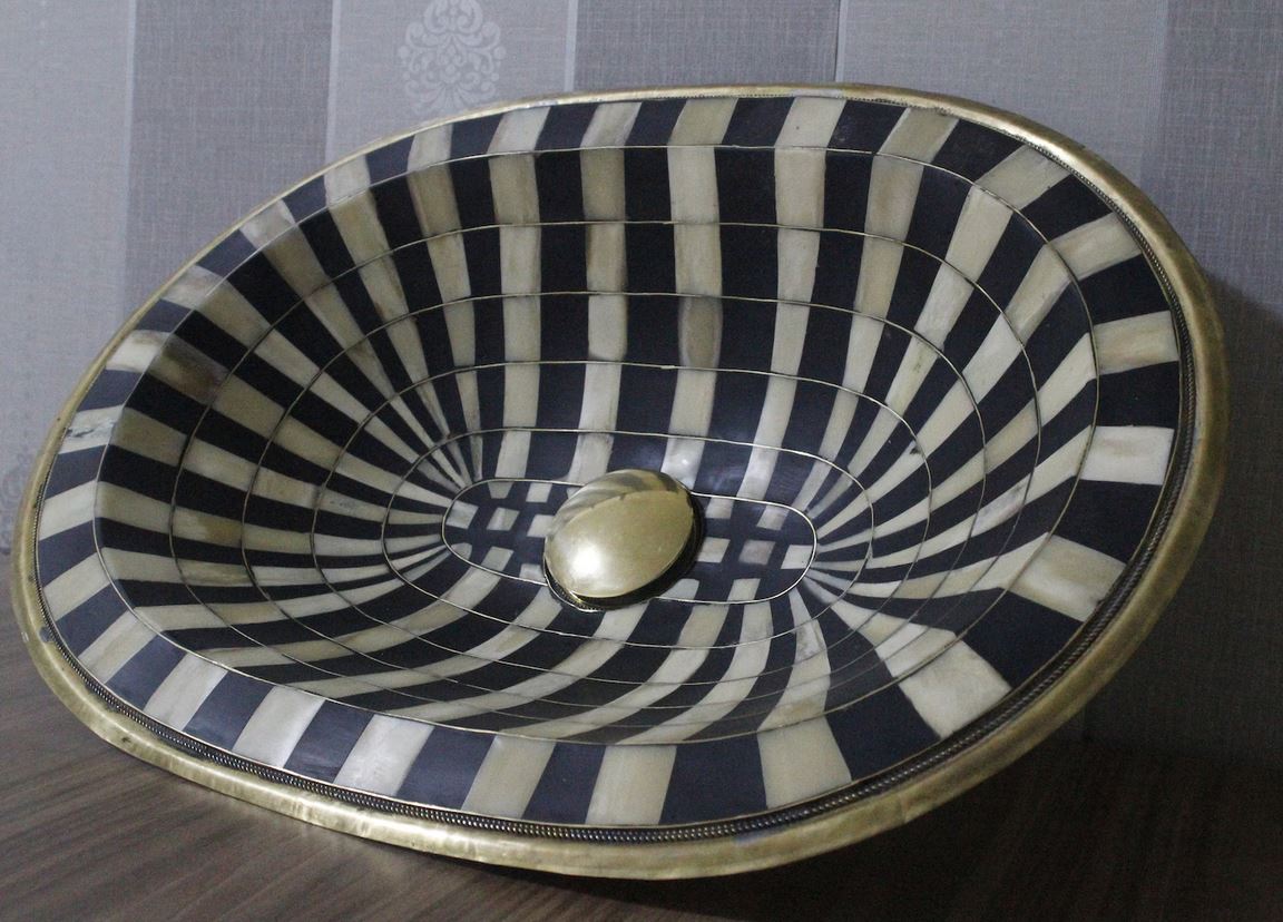 Stunning black and white oval drop-in sink featuring a single hole, resilient brass, and resin basin.